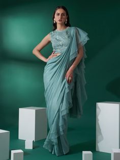 This is a two-piece sea green pre draped ruffle saree set from the Suruchi Parakh collection. The sea green pre draped ruffle saree in georgette crepe is paired with a hand-embroidered blouse. The satin base blouse has padding, and a cut-out detail at the back with hook opening. There is beautiful floral hand-embroidery and thread work all over the blouse with buttis. This sea green pre draped ruffle saree set is crafted in georgette crepe, organza and satin materials. Ruffle Saree Blouse, Ruffle Saree Designs, Online Shopping Sarees, Lehenga Gown, Ruffle Saree, Drape Saree, Purple Satin, Blouse For Women, Fancy Sarees