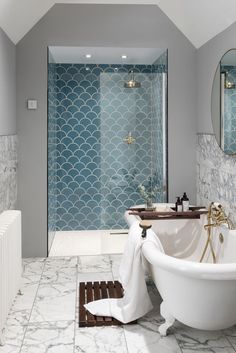 a white bath tub sitting next to a walk in shower