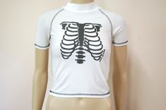 "FREE SHIPPING WORLDWIDE FOR ALL ADDITIONAL ITEMS PURCHASED  -1990s vintage white rib cage skeleton rashie top -Super petite tight fit -Spandex stretch fabric -High rounded neckline -Semi sheer and lightweight MEASUREMENTS:  - Length: 48cm (19\") - Bust: 46cm (18\") - Waist: 46cm (18\") - Armhole width: 16cm (6.6\") Material: Polyester/Spandex Estimated fit: XXS-XS Condition: It looks slightly a pale yellow on front. Excellent vintage Measurements taken while garment is laying flat x2 for full circumference. Check the measurements before purchasing. Your item will be sent within 1 business day.♡" Fitted Rave T-shirt For Streetwear, Fitted Y2k T-shirt For Halloween, White Fitted Punk Style Tops, White Fitted Punk Top, Fitted Grunge Skull Print T-shirt, Fitted Grunge T-shirt With Skull Print, White Fitted Punk T-shirt, White Rave Crew Neck Top, Fitted White Rave Tops