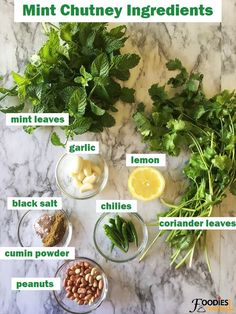 the ingredients for mint chutney ingredients on a marble counter with green herbs and lemons