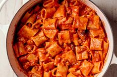 a pot filled with pasta and sauce on top of a table