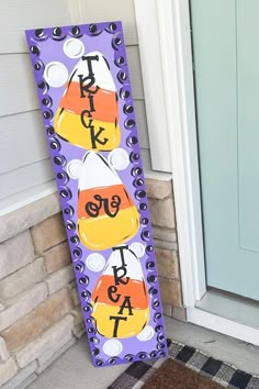 a door hanger that says trick or treat with candy on it, sitting in front of a house