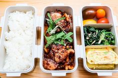 three plastic containers filled with food on top of a wooden table next to vegetables and rice