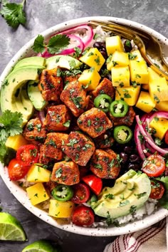 a bowl filled with meat and vegetables on top of rice next to sliced avocado