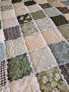 an old quilt is laying on top of a tablecloth that has been made into a blanket