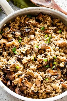 a pot filled with rice and mushrooms on top of a table