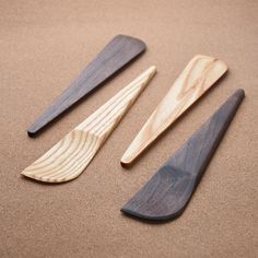 three wooden spoons are laying on the sand and ready to be used in cooking