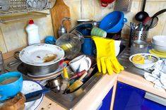 dirty dishes and kitchen utensils on the counter in a messy kitchen stock images