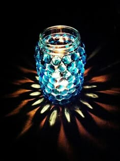 a glass jar with some blue beads on it