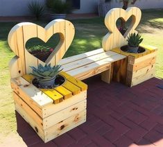 two wooden benches made to look like hearts with succulents in the middle