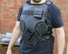 a man in a black shirt is wearing a body armor