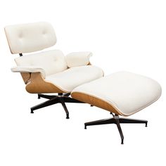 an eames lounge chair and ottoman with white cushions