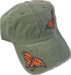 a green hat with an orange butterfly embroidered on the front and side of it's peak