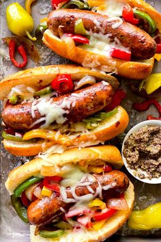 hot dogs with toppings and condiments are on a tray, ready to be eaten