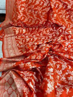 Stunning orange Katan Banarasi saree with golden zari jaal work. Crafted with precision and care, this saree is the perfect choice for any special occasion. The beautiful shade of pink adds a touch of femininity and elegance, while the intricate golden zari jaal work creates a mesmerizing effect. The Banarasi style of weaving, hailing from the holy city of Varanasi in India, is known for its intricate designs and high-quality craftsmanship. This saree is a true testament to the artistry of Banar Burnt Orange Saree, Orange Blouse Piece For Wedding And Eid, Unstitched Orange Blouse Piece For Wedding, Orange Art Silk Saree With Zari Work, Anarkali Orange Saree With Zari Weaving, Orange Silk Traditional Wear With Patterns, Orange Art Silk Blouse For Traditional Ceremonies, Orange Blouse Piece With Traditional Patterns And Drape, Orange Art Silk Dupatta For Wedding