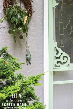 a wreath hanging on the side of a building next to a green door and window