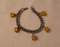 Gals, this fabulous bracelet is sure to make you feel like one lucky lady! An original vintage charm bracelet circa 1940s or 1950s, its a classic warm toned silver colour metal link chain bracelet, with 5 fully finished perfectly formed dice in a rich mustard toned plastic that is likely bakelite. Ace. Ready and waiting to finish that flawless 1940s or 1950s ensemble, and bring some ultra glamourous luck along the way.  Measurements:    Length: 7 1/4" long from furthest hinge on clasp to final r Retro Metal Jewelry For Gifts, Retro Metal Jewelry For Gift, Vintage Metal Charm Bracelet Handmade, Retro Metal Charms Jewelry, Vintage Handmade Metal Charm Bracelet, Adjustable Retro Nickel-free Jewelry, Handmade Vintage Metal Charm Bracelet, Vintage Metal Charm Bracelet For Gifts, Retro Metal Bracelets With Charms