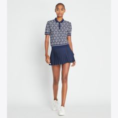 Designed to be worn on and off the court, a classic polo features a vintage-inspired racquet print and contrast striped rib-knit collar, cuffs and hem. Crafted in a comfortable and breathable tech knit, the versatile top can dress up with trousers or down with a pleated tennis skirt. Classic Fitted Polo Sweater With Striped Collar, Casual Polo Sweater With Contrast Stripes, Casual Collared Polo Sweater With Contrast Stripes, Sporty Polo Sweater With Ribbed Cuffs, Sporty Collared Polo Sweater With Ribbed Cuffs, Tory Burch Outfits, Overlay Skirt, Pleated Tennis Skirt, Tennis Skirt