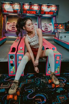 a woman sitting on top of a pinball machine