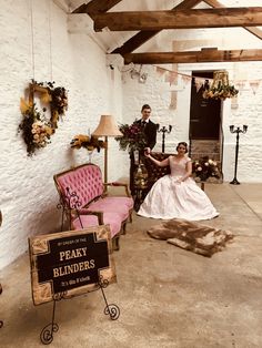 a man and woman in wedding attire sitting next to each other on pink couches