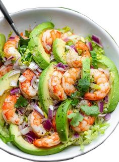 a salad with shrimp, avocado and cilantro in a white bowl