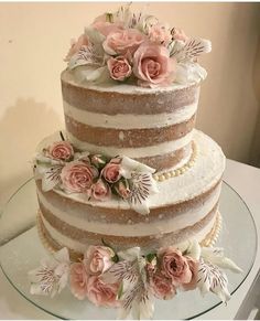 a three layer cake with pink flowers on top