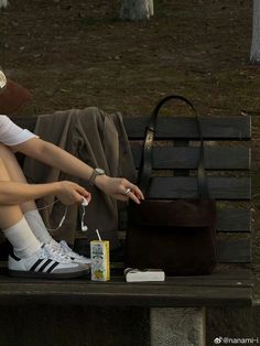 a woman is sitting on a bench with her purse