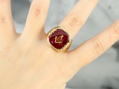 "This large vintage red glass Masonic ring has amazing, yet simply detailed shoulders, rising up from the shank and bending around the corners of the stone. The center is a classic red glass cabochon, inlaid with the gold Masonic symbol, with a nice flat profile. This ring has a substantial feel to it, and makes for a classic Masonic piece! Metal: 14K Yellow Gold Gem: Red Glass Cabochon, Gold Inlaid Masonic Symbol Gem Measures: 16mm x 14mm, Square Cushion Cut Size of Ring: 10 Marks: \"14K\" and Heirloom Red Signet Ring With Polished Finish, Elegant Red Intaglio Signet Ring, Red Oval Intaglio Ring, Classic Red Round Jewelry, Luxury Red Cabochon Ruby Ring, Collectible Red Engraved Ring, Classic Red Signet Ring For Formal Occasions, Classic Red Intaglio Ring, Heirloom Style Red Signet Ring With Gemstone