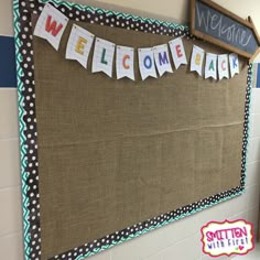 a welcome sign is hanging on the wall next to a bulletin board that says welcome