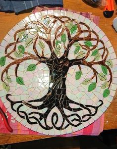 a plate with a tree on it sitting on top of a table next to scissors