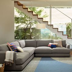 a living room filled with furniture next to a stair case