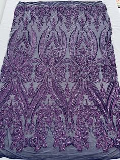 purple sequins on grey fabric with white table cloth in the background and an image of