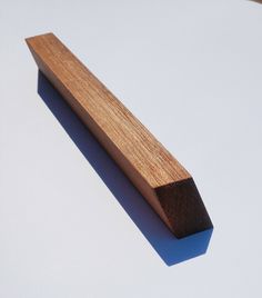 a piece of wood sitting on top of a white table next to a wooden object