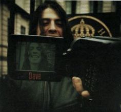 a man holding up an old tv with the word rave on it in front of his face