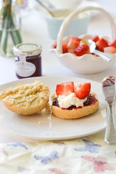 two pastries on a plate with strawberries and cream