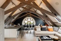 a living room filled with furniture next to a kitchen and dining area in a loft