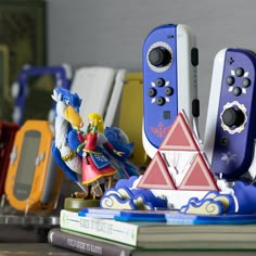 several nintendo wii game controllers sitting next to each other on top of a book shelf