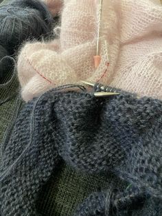 a pair of scissors and some yarn sitting on a table next to a piece of cloth