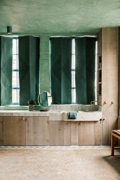 a large bathroom with two sinks and green curtains