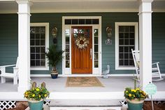 the front porch is decorated with flowers and wreaths