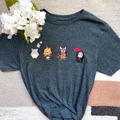 Some of your cute Studio Ghibli characters representing all the four seasons of the year on a shirt! * Totoro represents Spring * Calcifer represents Summer * Jiji represents Autumn * Kaonashi represents Winter Shirts are available in heather gray and black  HOW TO ORDER  → Please pick your t-shirt size → Please pick your t-shirt color → Select the quantity → Click add to cart  ABOUT PPRODUCT  Brand of Shirt: GILDAN Softstyle Solid Colors: 35/65 cotton/polyester Tearaway label All shirts are ver Fun Anime Print Crew Neck T-shirt, Fandom Cartoon Print Cotton T-shirt, Cotton Fandom Shirt With Cartoon Print, Cotton Fandom T-shirt With Cartoon Print, Themed Cotton Short Sleeve Tops, Fun Cartoon Print Tops For Fan Conventions, Themed Short Sleeve Tops With Funny Print, Fandom Halloween Short Sleeve Tops, Fan-themed Short Sleeve Tops