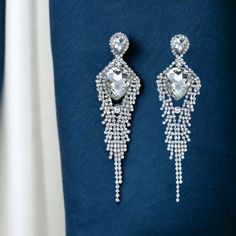 Style: Marquise pointed teardrop pave accented rhinestone statement earrings Color: Diamante rhinestones on silver Length: 5.25″ Post W/Pushback Closure Dazzling Teardrop Chandelier Earrings With Diamond Accents, Diamond White Sparkling Chandelier Earrings For Party, Sparkling Diamond White Chandelier Earrings For Party, Dazzling Teardrop Crystal Chandelier Earrings, Diamond White Dangle Crystal Earrings With Rhinestones, Glamorous Silver Teardrop Crystal Earrings, Dazzling Silver Crystal Chandelier Earrings, Silver Earrings With Rhinestones For Glamorous Events, Silver Rhinestone Earrings For Glamorous Events