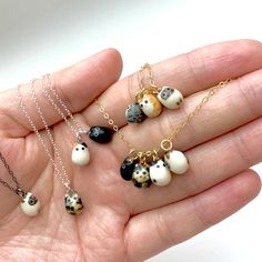 a hand holding several different necklaces in it's palm