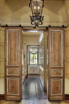 an open door leading to a hallway with two lamps on either side and another light hanging from the ceiling