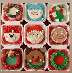 there are many decorated cupcakes in the box on the table with christmas decorations