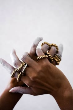 two hands holding different types of rings on each other's fingers, with one hand in the air