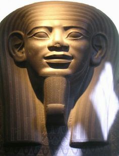 an egyptian statue with a microphone in it's mouth and light shining on the face