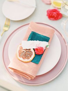 a pink plate topped with a grapefruit and orange slice