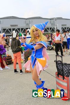 a woman dressed in costume is posing for the camera with luggage and people behind her