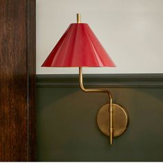 a red lamp sitting on top of a wall next to a wooden door and green walls